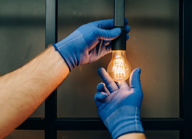 Electrician changes the light bulb, handyman