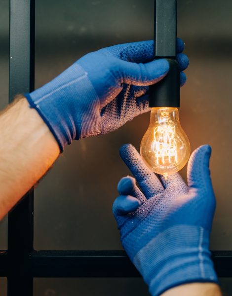 Electrician changes the light bulb, handyman